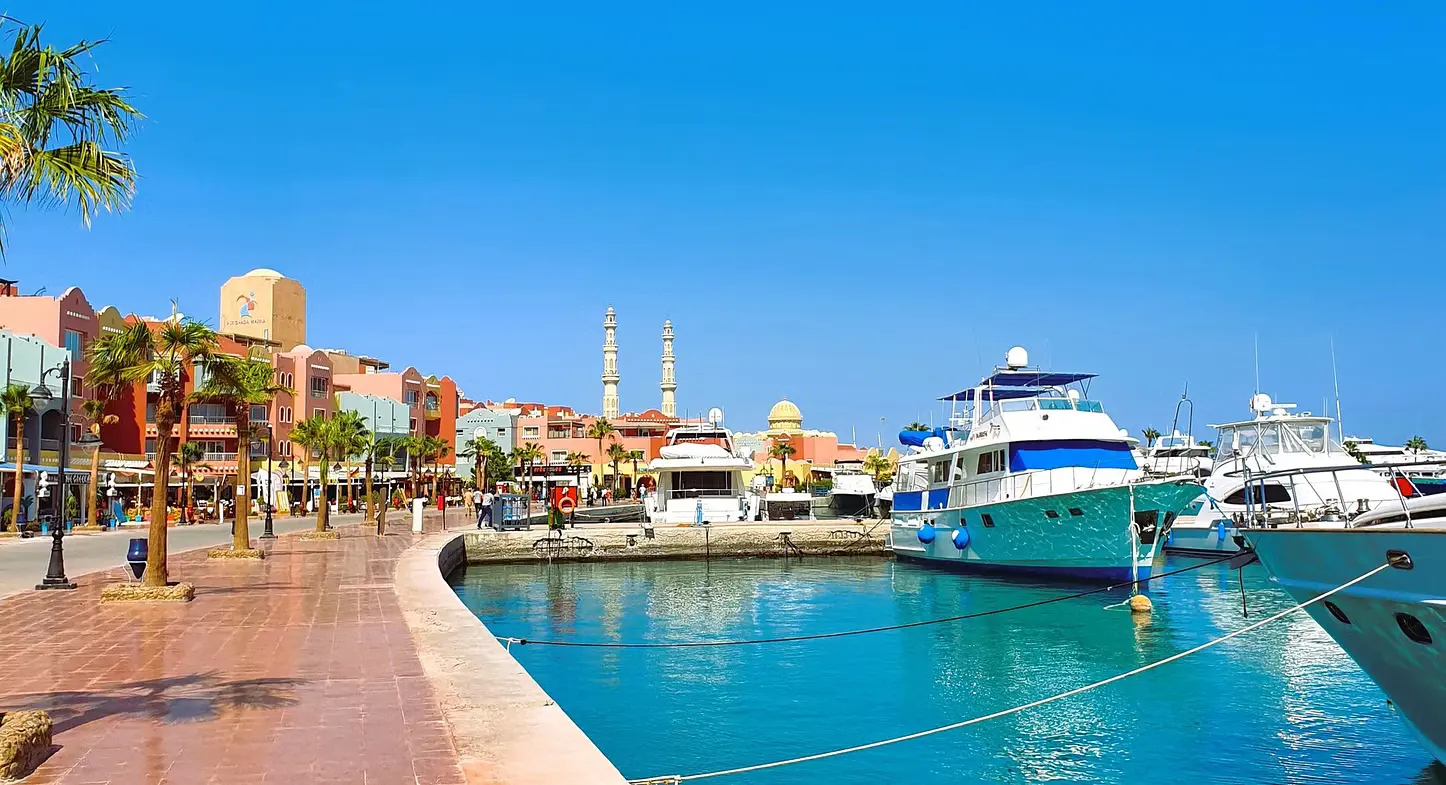 Tourists walking through a bustling market in Hurghada, Egypt, with colorful shops selling local goods. A traditional Egyptian meal served on a table in a local restaurant.