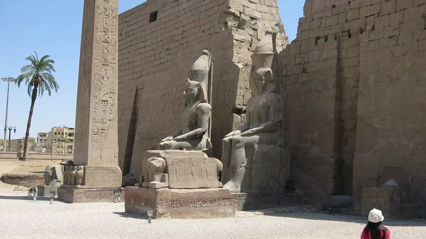 Majestic view of the Karnak Temple with towering columns and hieroglyphs, alongside the grand Luxor Temple lit by the setting sun on Luxor's East Bank.